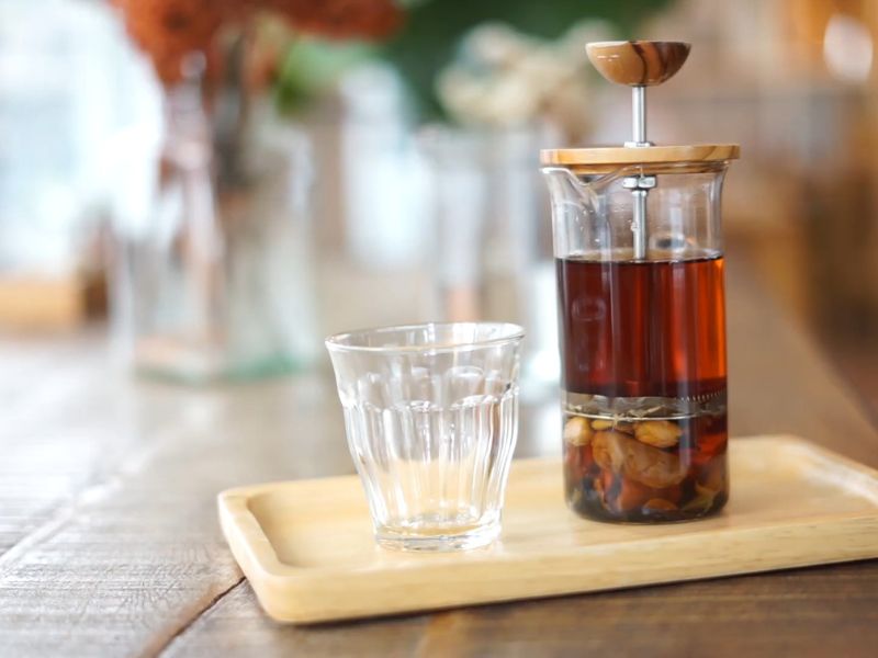 dozer sa kuvanim čajem na rifuzu i staklena čaša za čaj