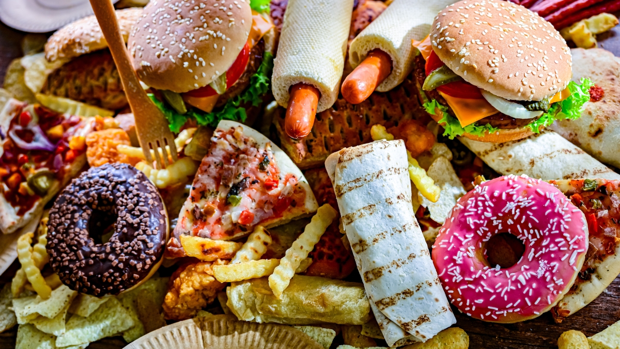 Burgeri, krofne, pomfrit i grickalice složeni su na stolu